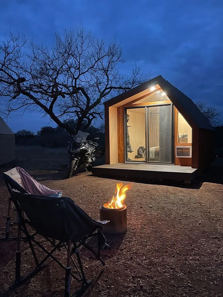 Cabin at night with campfire